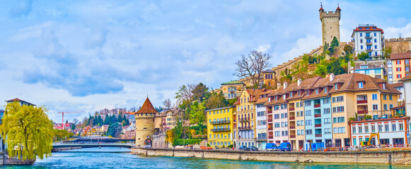 Panorama of Reuss river's townhouses and medieval towers on Museggmauer walls on the hill, Lucerne,...