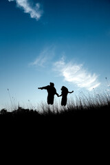 silhouette of two girls jumping