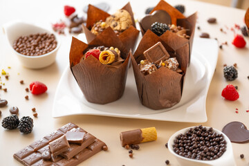 muffin set. cupcake with raspberries and crispy waffles,chocolate decor on a beige background.Chocolate dessert.Chocolate cupcake.Assorted sweet table.Baked goods and desserts 