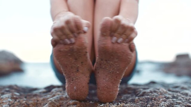Sand feet, relax and woman barefoot while enjoying beach holiday travel with outdoor close up. Summer, ocean and vacation getaway happiness and fun at seaside with playful hands touching toes.