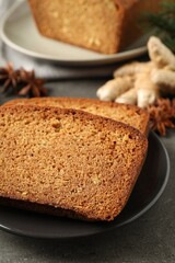 Fresh gingerbread cake slices served on grey table, closeup