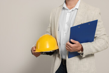 Professional engineer with hard hat and clipboard on white background, closeup