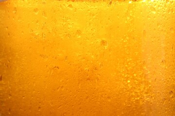 Glass of tasty cold beer with condensation drops as background, closeup