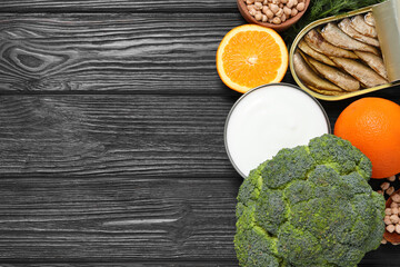 Set of natural food high in calcium on black wooden table, flat lay. Space for text