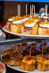Typical snack of Basque Country and Navarre, pinchos or pinxtos, small piece of bread with different toppings, served in bar, Bilbao, Spain