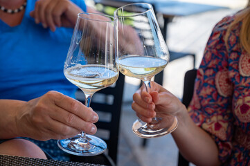 Drinking of txakoli or chacolí slightly sparkling very dry white wine produced in Spanish Basque Country, served in restaurant in Getaria, Spain