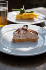 Sunny day in San Sebastián, typical food and drink in bars of Basque Country, pinchos or pinxtos, small slices of bread with different toppings and glass of beer, lunch in Spain