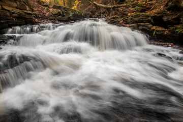 tranquil landscape of silky cascading water  against vibrant autumn forest background in Pennsylvania 
