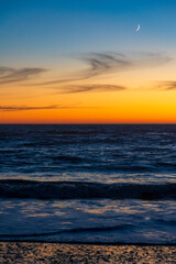 dramatic sunset in Rialto Beach in Olympic National Park in Washington State with silouhette of sea stacks on the background.