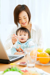 Obraz na płótnie Canvas 赤ちゃんにご飯を食べさせる母親