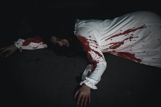 The girl was hit by a car and lying died on the road. full of blood left unattended, Horror bloodthirsty woman ghost horror she death and scary at night in tunnel, Happy halloween day concept