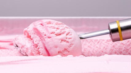 Close-up shot of strawberry ice cream scooped out of the container.