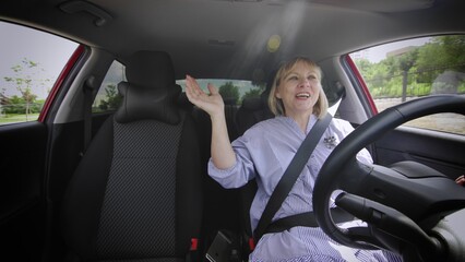 An adult woman sings songs while driving a car