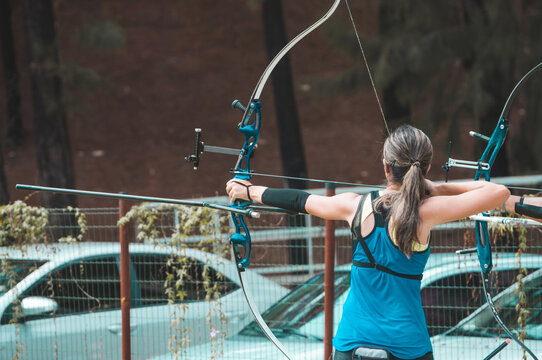 o antigo esporte de arco e flecha com uma mulher treinando a pontaria para acertar o alvo e disparando a flecha com toda t&eacute;cnica envolvendo posicionamento e concentra&ccedil;&atilde;o