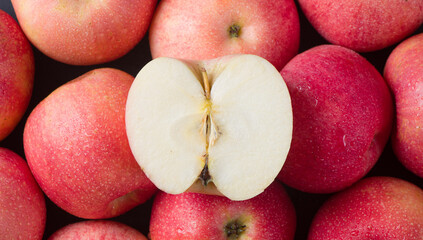 Red ripe apples and cut apples background