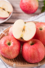 Red ripe apples and cut apples on on wooden board background