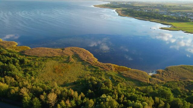 Aerial view of Zatoka Pucka in Poland with green shoreline and tranquil water at sunset time