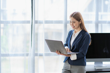 Asian women work online at home using laptop computers to work, surf the web and greet people via video calls.