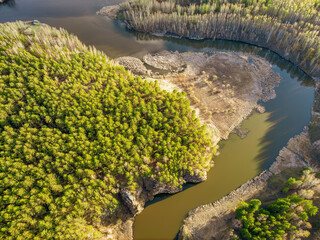Aerial view of river shore with rocks and forest. Spring or autumn season. Iset River, Ural mountains, Russia.
