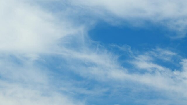 Blue sky with white cirrus clouds. Sunny background, blue sky with white cirrus clouds. Time lapse.