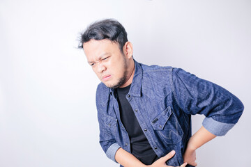 Asian handsome man suffering from backache for having made an effort over isolated white background