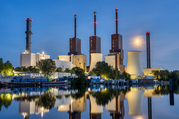A thermal power station in Berlin at night reflected in a canal