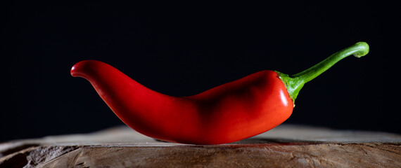 A red chilli against a black background