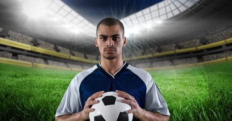 Composition of male football player holding football over sports stadium