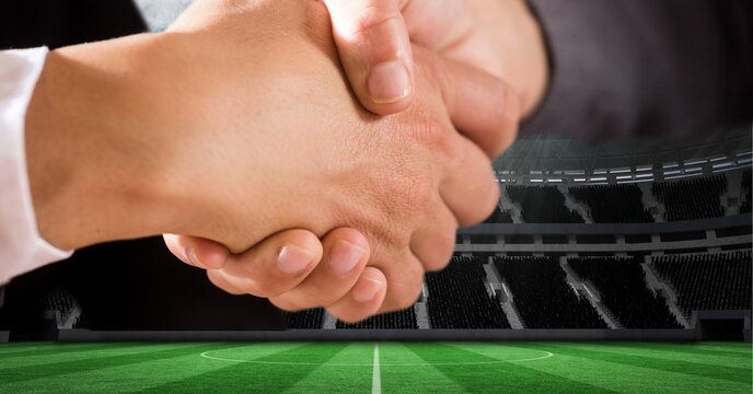 Composition of businessman and businesswoman shaking hands over sports stadium