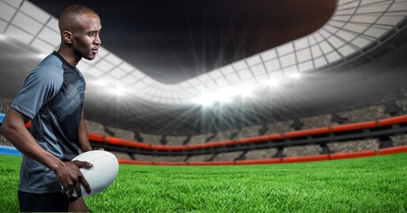 Composition of male rugby player holding rugby ball over sports stadium