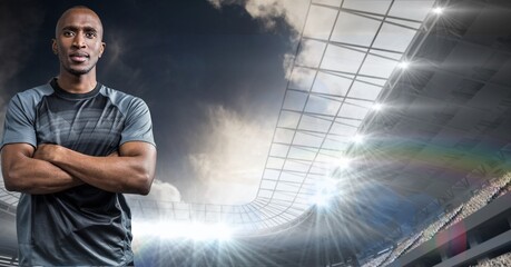 Composition of male rugby player with arms crossed over sports stadium