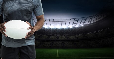 Composition of male rugby player holding rugby ball over sports stadium