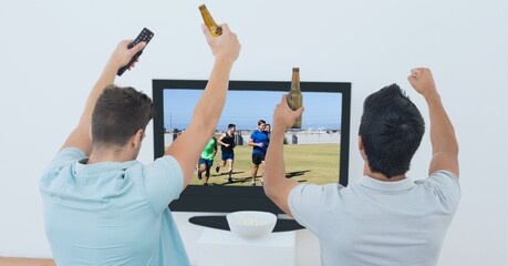 Composition of two male sports fans watching football match on tv