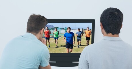Composition of two male sports fans watching football match on tv