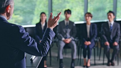 登壇する男性と聴衆　セミナー　プレゼンテーション