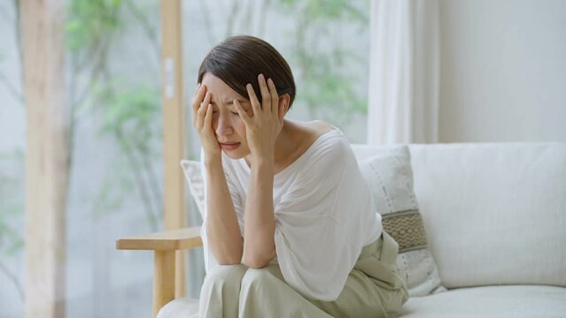 60p　リビングで落ち込むミドル女性