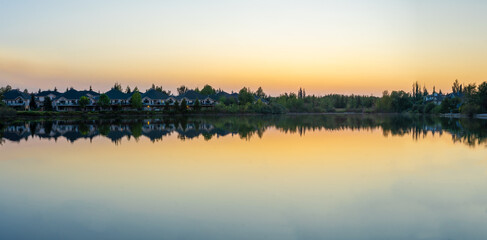 suburban houses beside a lake at sunset