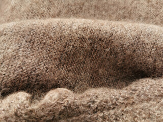 Hand-knitted texture close-up.  Natural hand-knitted wool shawl. Warm cozy knitted clothes or handmade plaid, blurred background. Russian down shawl made of goat or sheep wool