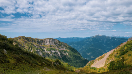 Alpine Meadows Trail, Krasnaya Polyana Resort. Alpine Meadows Walking Route. Aerial view of the green mountain valley, surrounded by high mountains.