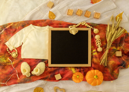 Mockup Of Baby Bodysuit Shirt . Thanksgiving Baby Announcement. Fall Pregnancy Announcement Letterboard Baby Announcement. Pregnancy Announcement Background With Blurred . Selective Focus