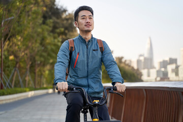 young asian adult man commuting by bicycle
