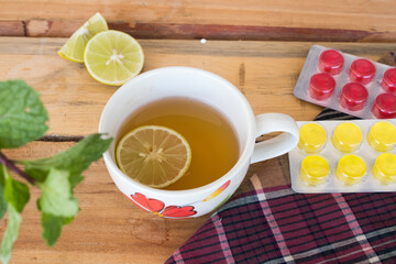 honey lemon herbal drinks with lozenge for health care arrangement flat lay style on background wooden