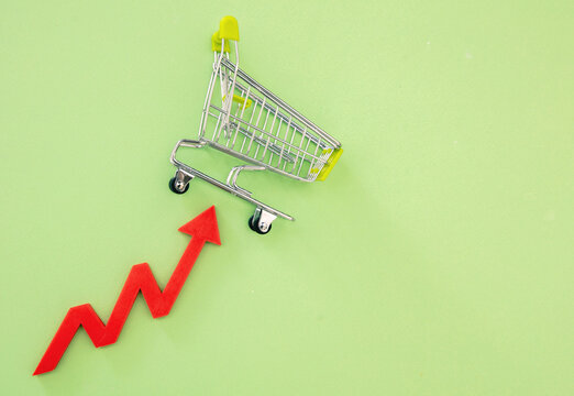 Shopping cart and red arrow up. Groceries price up, food rising cost.