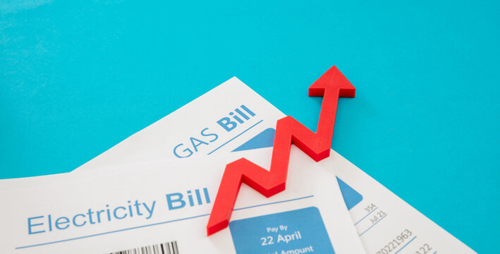 Electricity and gas bills and red rising up arrow. Heating and energy cost increase