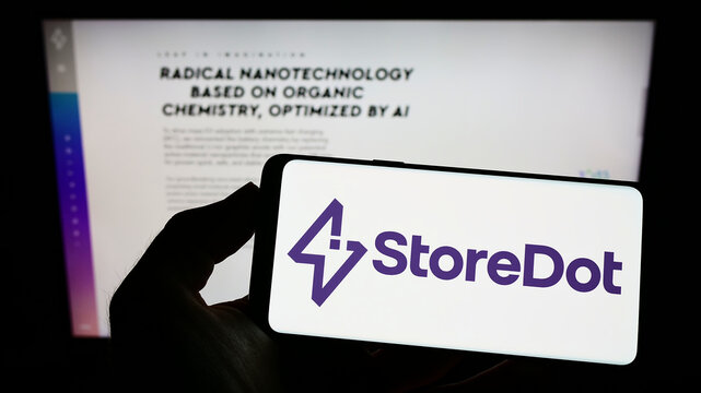 Stuttgart, Germany - 09-09-2022: Person holding mobile phone with logo of Israeli battery company StoreDot Ltd. on screen in front of business web page. Focus on phone display.
