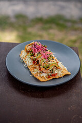 Homemade shrimp tacos with coleslaw and salsa served on a blue plate