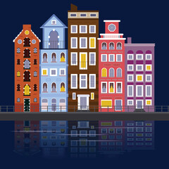 Beautiful night view of the colorful facades of historic buildings in Amsterdam reflected in the river. Beautiful cityscape.