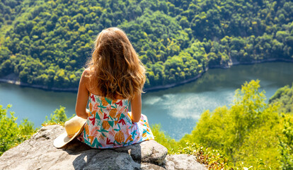 Woman sitting on mountain peak enjoying dordogne river view