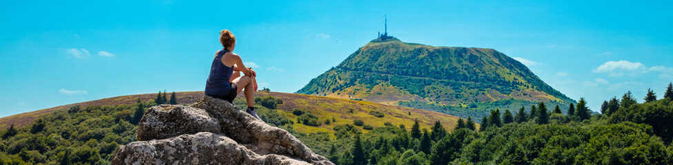 Woman sitting on mountain peak looking at panorama view