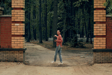 young woman in casual clothes is relaxing in an old park
